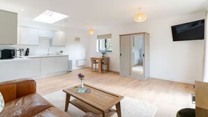 A modern living space with a kitchen, dining area, and seating area.