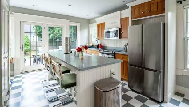 A modern kitchen with a central island, stainless steel appliances, and a checkered floor. - Sunny House, By The Beach, Minutes From Portland (South Portland)