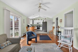 A spacious living room with a dining area, kitchen, and a view of the outdoors.