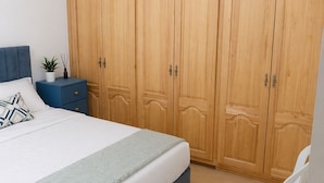 Une chambre à coucher avec un lit, une table de chevet, une commode et une chaise.