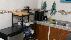 A compact kitchen with a refrigerator, a coffee maker, and a sink. - Beautiful Appartment in The Heart of Essaouira. The safest area. (Essaouira)