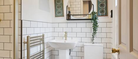 Un baño con lavamanos, inodoro y toallero.