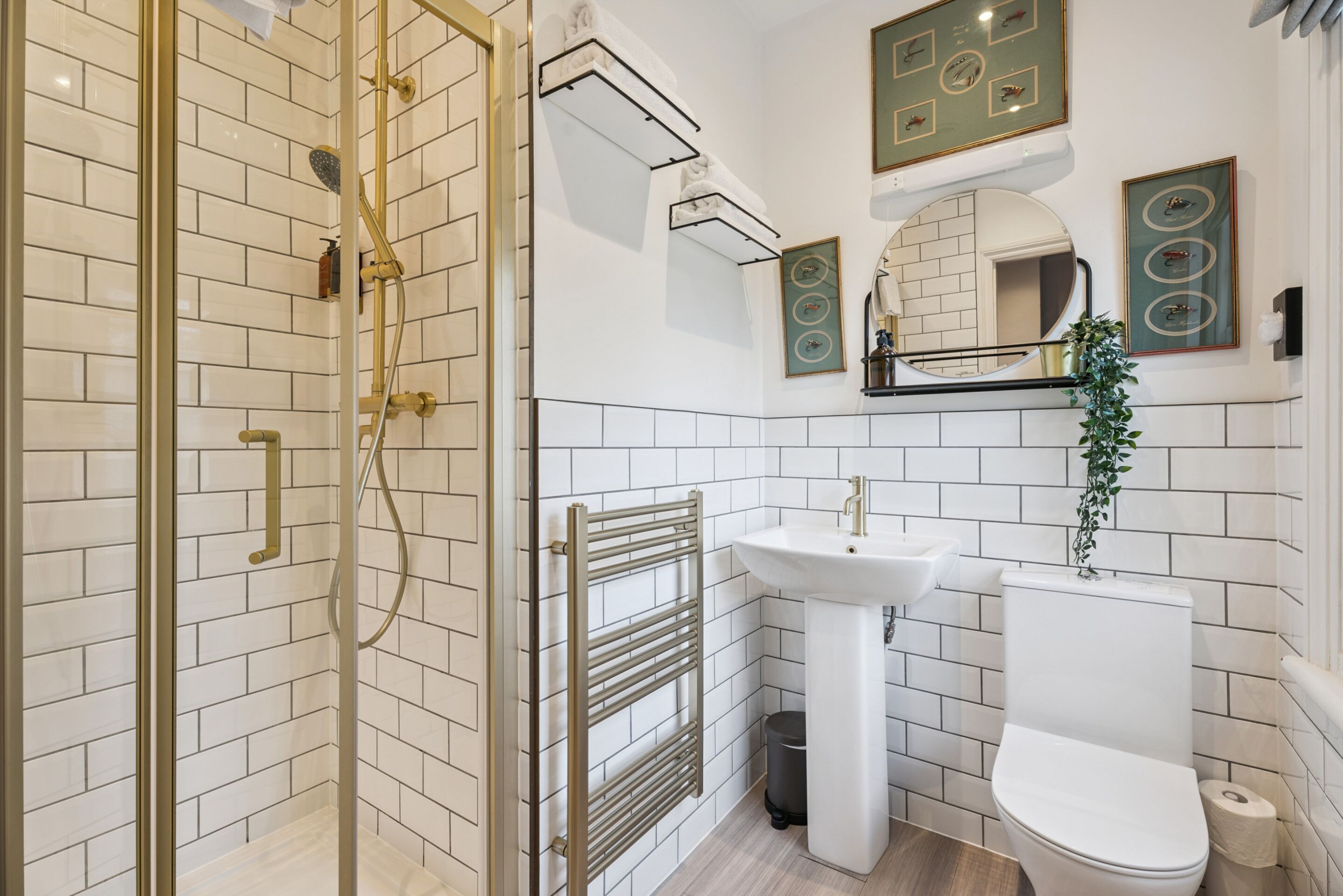 A bathroom with a glass-enclosed shower, a pedestal sink, and a toilet.