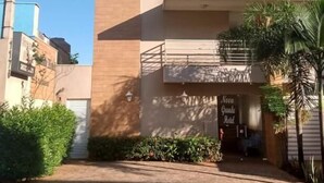 A hotel entrance with a modern design, a visible sign for 'Hotel Grande Hotel,' and a gated driveway. - novo grande hotel  (Ribeirão Preto)
