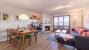 Ein Wohnzimmer mit Kamin, Essbereich und einer Couch.