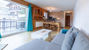 A modern living room with a large window, a dining area, and a kitchen. - Mélèzes R 030 - SKI LIFT apartment 6 pers (Veysonnaz)
