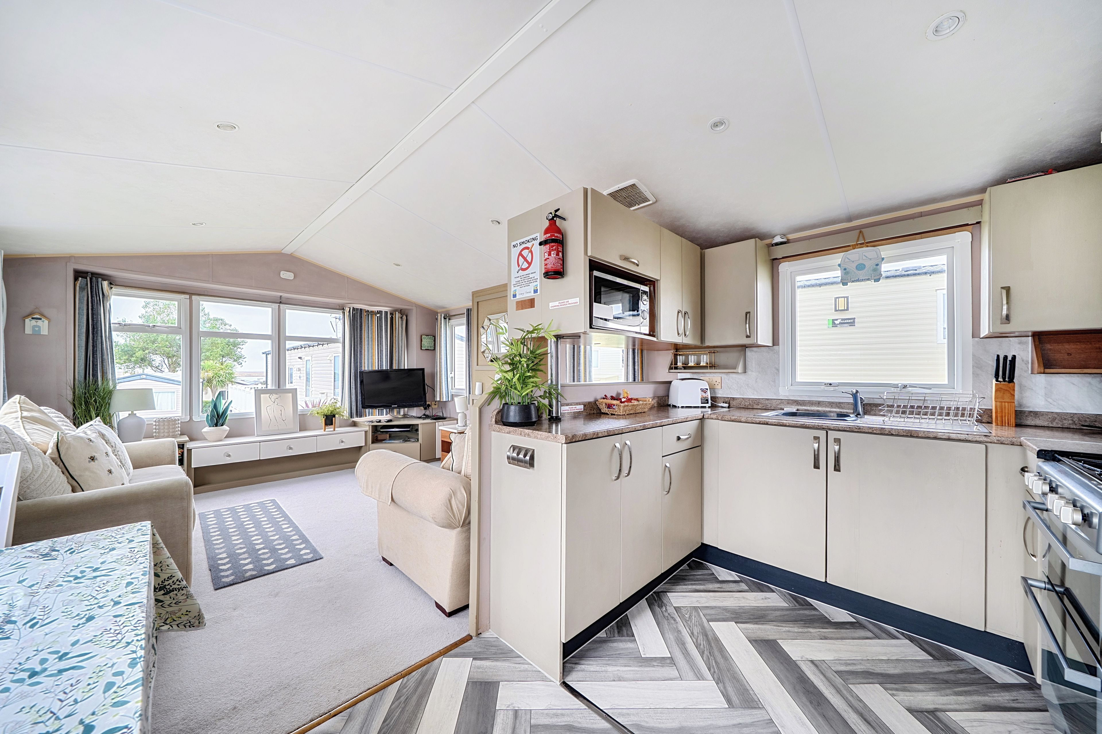 A compact living space with a kitchenette, a sofa, a television, and a dining area.