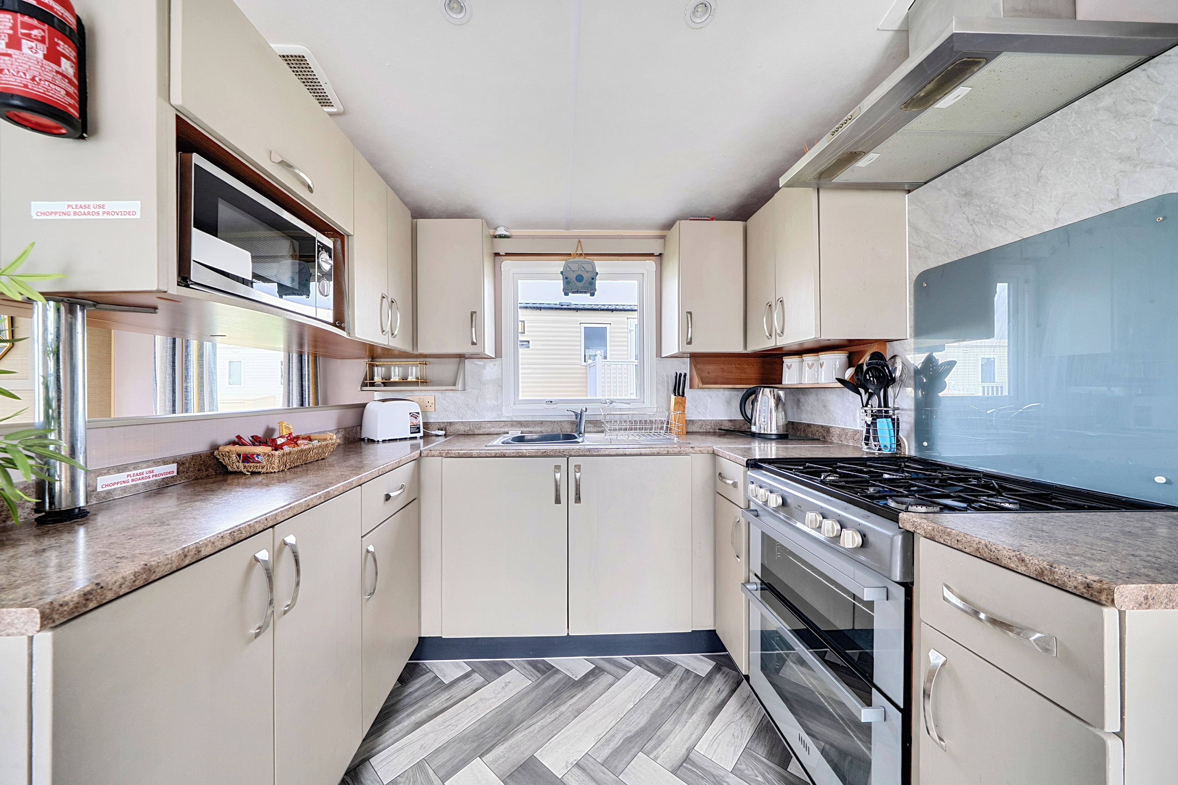A compact kitchen with a microwave, stove, and sink.