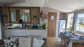 Una cocina compacta con comedor, un sofá con cojines estampados y vistas a través de la ventana.