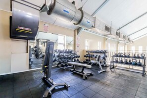 A gym with exercise equipment, a bench, and a wall-mounted air conditioning unit. - 2-bedroom apartment in Cape Town with magnificent views of Table Mountain (Cape Town)