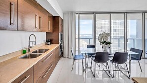 Una cocina moderna con comedor, ventanas amplias y vistas a la ciudad.
