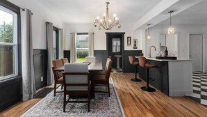 Et moderne køkken med spiseplads, en lysekrone og en bar.