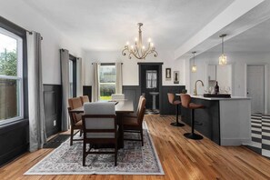 A modern kitchen with a dining area, a chandelier, and a bar. - Sleeps 10|5BR 2.5Ba Home|Near Plaza+Pets Welcome (Kansas City)
