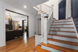 A staircase with wooden steps and white railings, leading to a landing. - Sleeps 10|5BR 2.5Ba Home|Near Plaza+Pets Welcome (Kansas City)