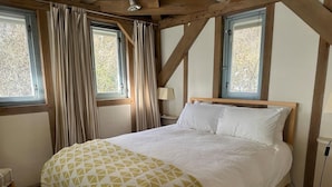 A bedroom with a wooden ceiling, a bed with a patterned bedspread, two windows with curtains, and a bedside lamp. - Tigh na Mara - Sleeps 4, Sea Views & Pet Friendly (Oban)