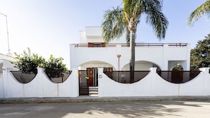A modern building with a white facade, arched doorways, and a palm tree in front. - SALENTINE DAYS - 2 (Torre Lapillo)