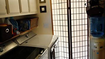 A laundry area with a washing machine, dryer, and a water dispenser.