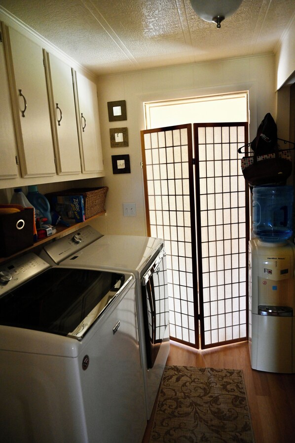 A laundry area with a washing machine, dryer, and a water dispenser.
