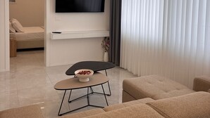 Un salon moderne doté d’un téléviseur à écran plat, d’un canapé, d’une table basse et d’un coin repas.