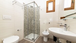 A modern bathroom with a glass-enclosed shower, a toilet, a bidet, and a sink with a mirror. - SALENTINE DAYS - 3 (Torre Lapillo)