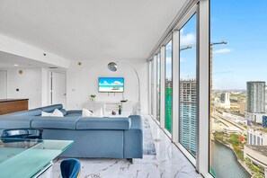 A modern living room with a large sofa, a coffee table, and a TV mounted on the wall. - Icon Brickell 2BDR 44th Fl Ocean Views+Spa Access (Miami)
