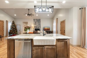 A modern kitchen with a large island, wooden cabinets, and a built-in dishwasher. - Welcome to Willow house. Your home away from home. (Pinetop-Lakeside)