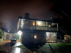 A two-story stone house with a balcony, a patio, and a small pond. - 'A Leira' House with Mountain Views, Private Pool and Garden (Ponteareas)