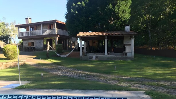 Ein Pool mit geometrischem Fliesenmuster, eine Hängematte und ein Gebäude mit einem Balkon.