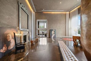 Eine geräumige Lobby mit einem imposanten Kamin, einem großen Porträt und einer Bank.