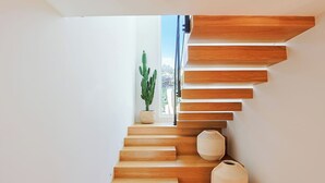 Eine moderne Treppe mit Holzstufen und einer Kakteenpflanze.