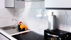 A modern kitchen with a built-in stove, a microwave, and a stainless steel range hood. - Oasis of Peace in the Middle of Town: Modern, Quiet and Close to Transportation (Genova)