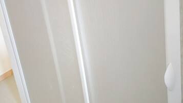 A white door with a handle, a white wall, and a wooden floor.