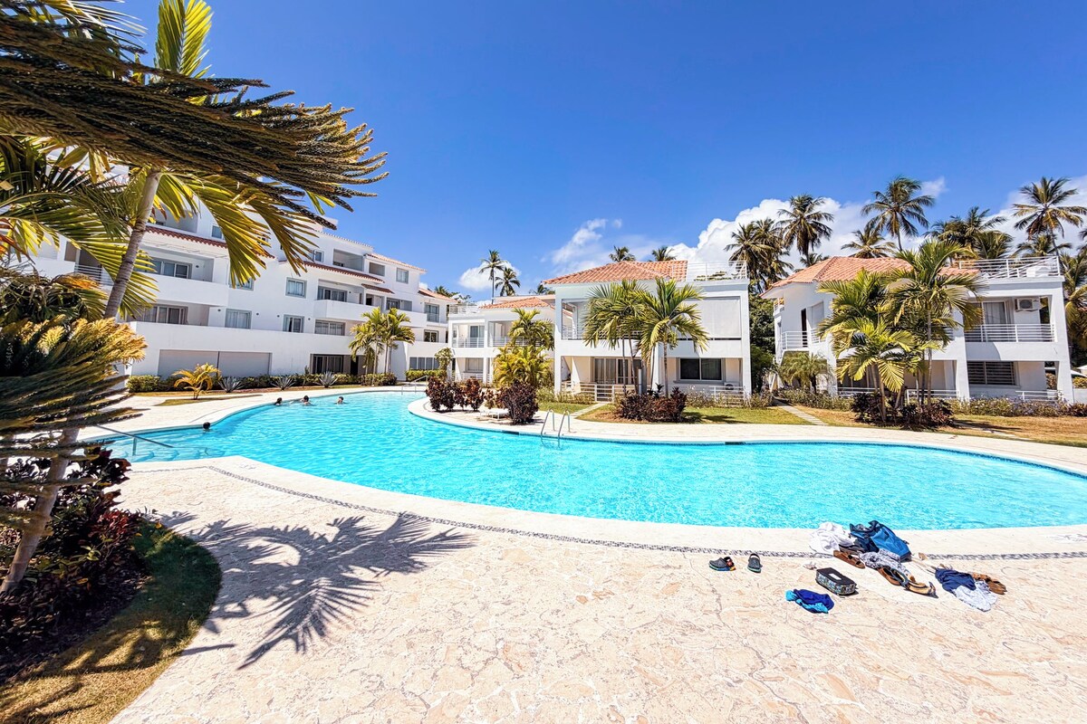 Un resort con piscina, palme e edifici a più piani.