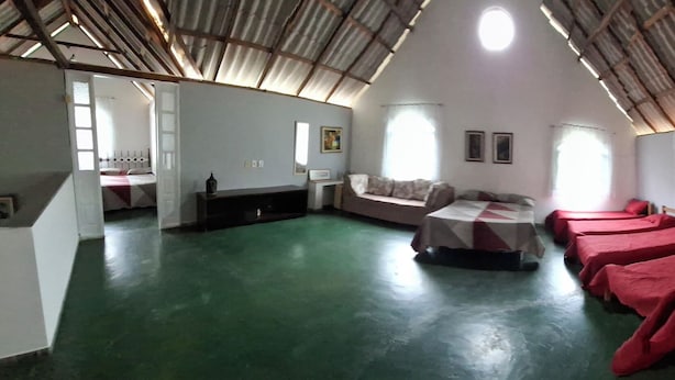 A dormitory room with bunk beds, a small table, and a window. - Sítio Siriruia 27 99998-6813  (Domingos Martins)