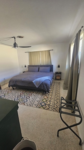 A bedroom with a bed, a ceiling fan, a desk, and a patterned rug. - Waterfront Getaway Near 3 Sister Springs (Crystal River)