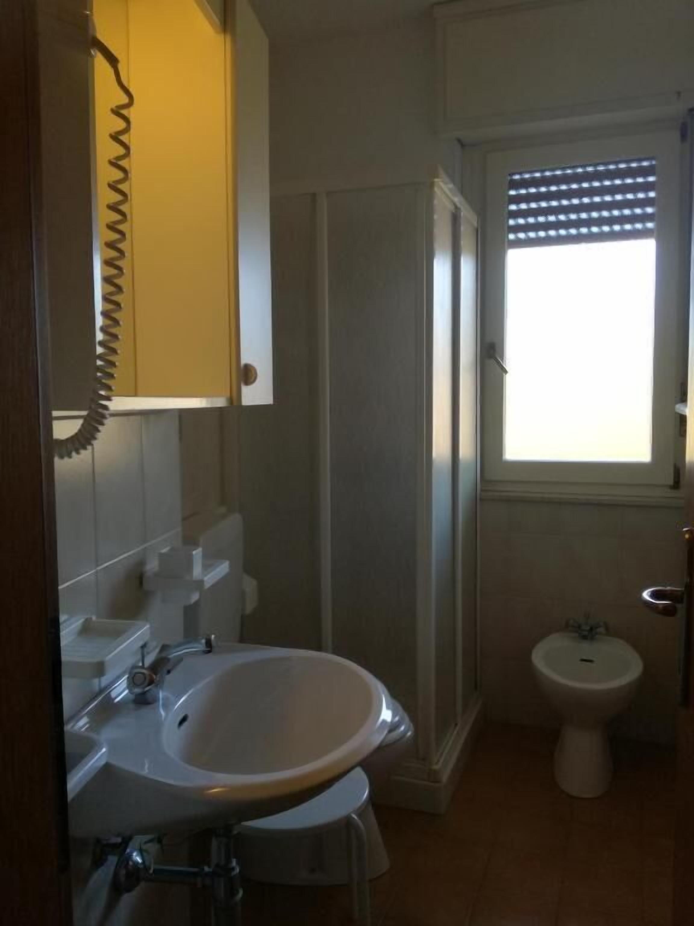 A bathroom with a sink, mirror, and toilet.