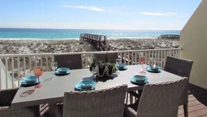 Un tavolo da pranzo con sedie e vista sulla spiaggia.