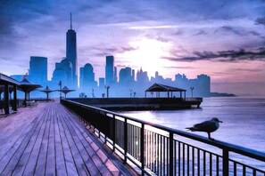 A waterfront promenade with a city skyline in the background.