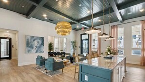 Amplia sala de estar con una isla grande, muebles modernos y un techo alto con vigas a la vista.