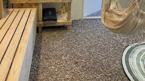 Una habitación con estante de madera que contiene equipo de ejercicio, una hamaca colgante y una pequeña mesa.