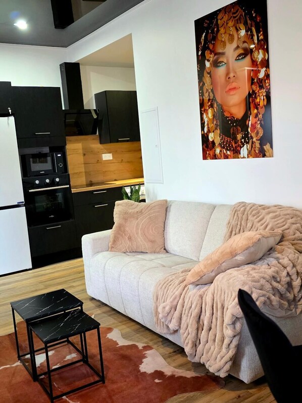 Un salon moderne avec un canapé, une table basse et une cuisine en arrière-plan.