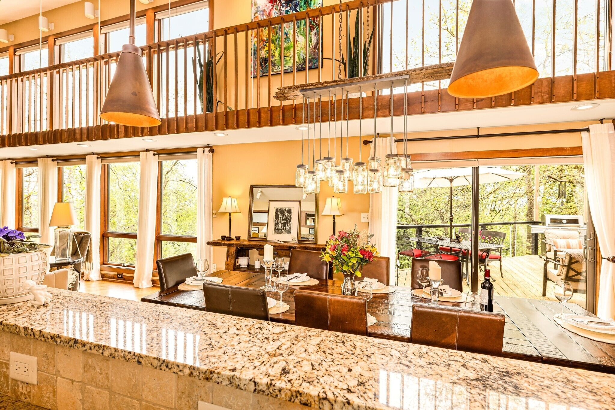 A spacious dining area with a high ceiling, large windows, and a view of the outdoors.
