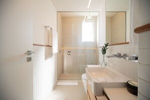 A modern bathroom with a glass-enclosed shower, a large white bathtub, and a mirror. - Ipanema Penthouse w/ Pool by the Beach (Rio de Janeiro)