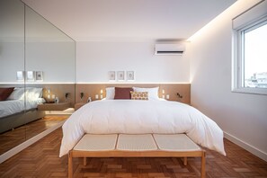 A modern bedroom with a large bed, a bench, a mirror, and a window. - Ipanema Penthouse w/ Pool by the Beach (Rio de Janeiro)