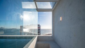 A modern room with a glass wall, a pool, and a view of the ocean. - Ipanema Penthouse w/ Pool by the Beach (Rio de Janeiro)