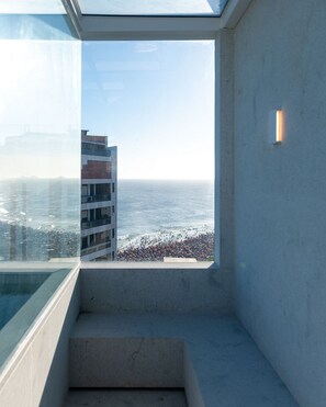 Un immeuble de grande hauteur offrant une vue sur la mer et la plage en contrebas.