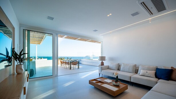 A modern living room with a sofa, coffee table, and a view of the ocean. - Ipanema Penthouse w/ Pool by the Beach (Rio de Janeiro)