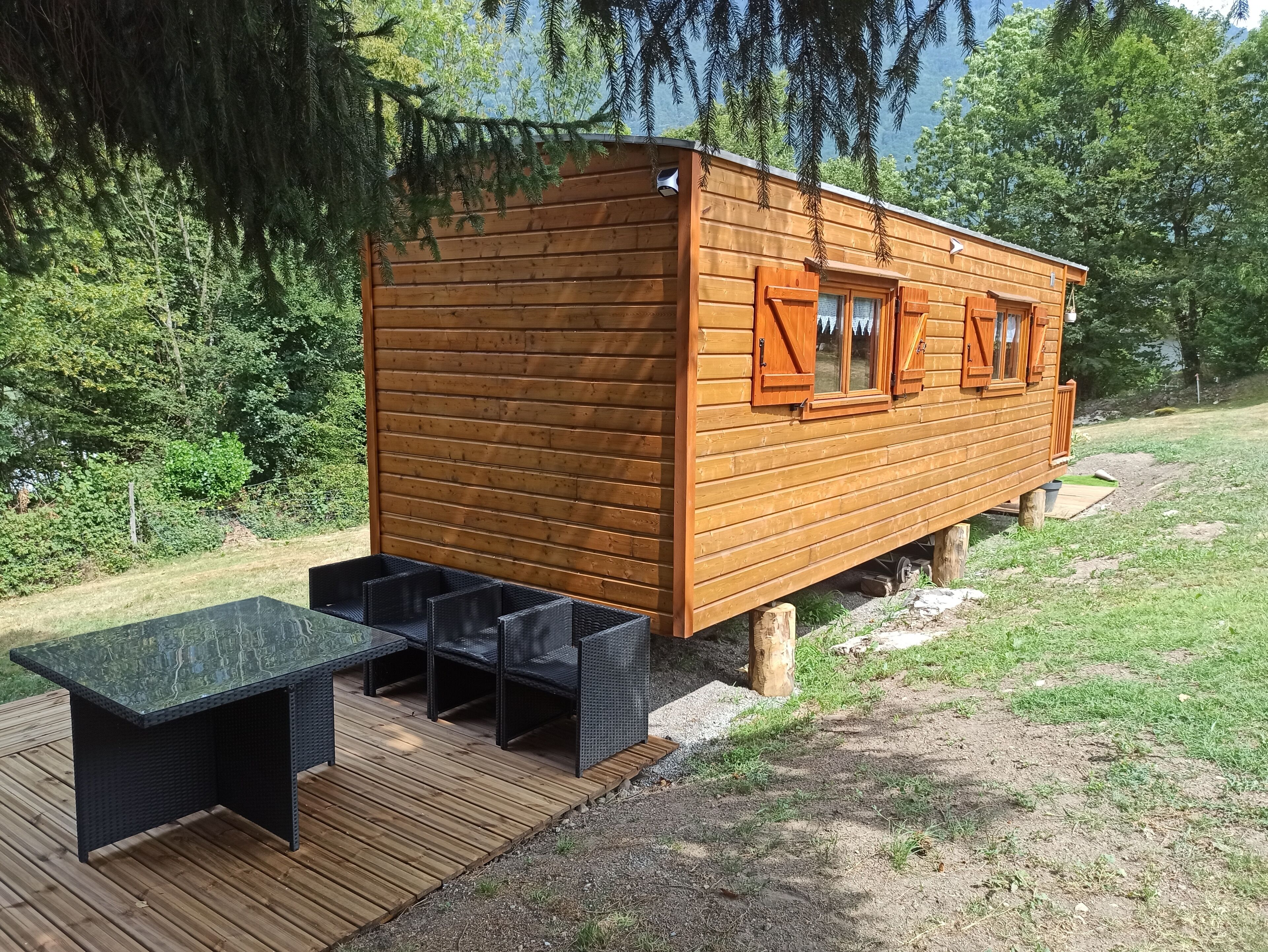 Una baita di legno con veranda e zona salotto all'aperto.