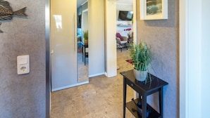 A hallway with a potted plant, a framed picture, and a fish decoration on the wall. - Vacation apartment Meeresrauschen (Hagermarsch)
