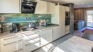 A modern kitchen with a built-in oven, a coffee machine, and a sink. - Vacation apartment Meeresrauschen (Hagermarsch)
